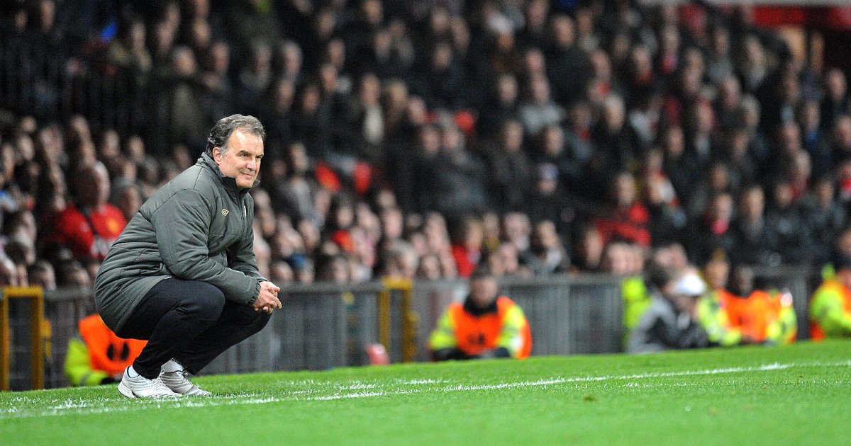 Marcelo Bielsa squats during Manchester United v Athletic Bilbao. Old Trafford, Manchester, March 2012.