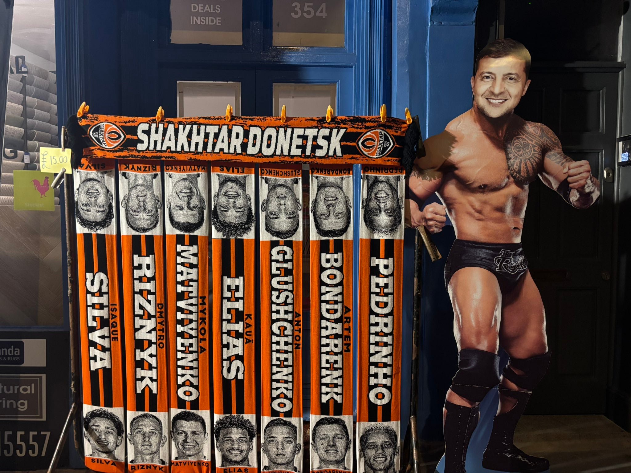 Shakhtar scarves next to a mock-up poster of President Zelenskyy as a wrestler