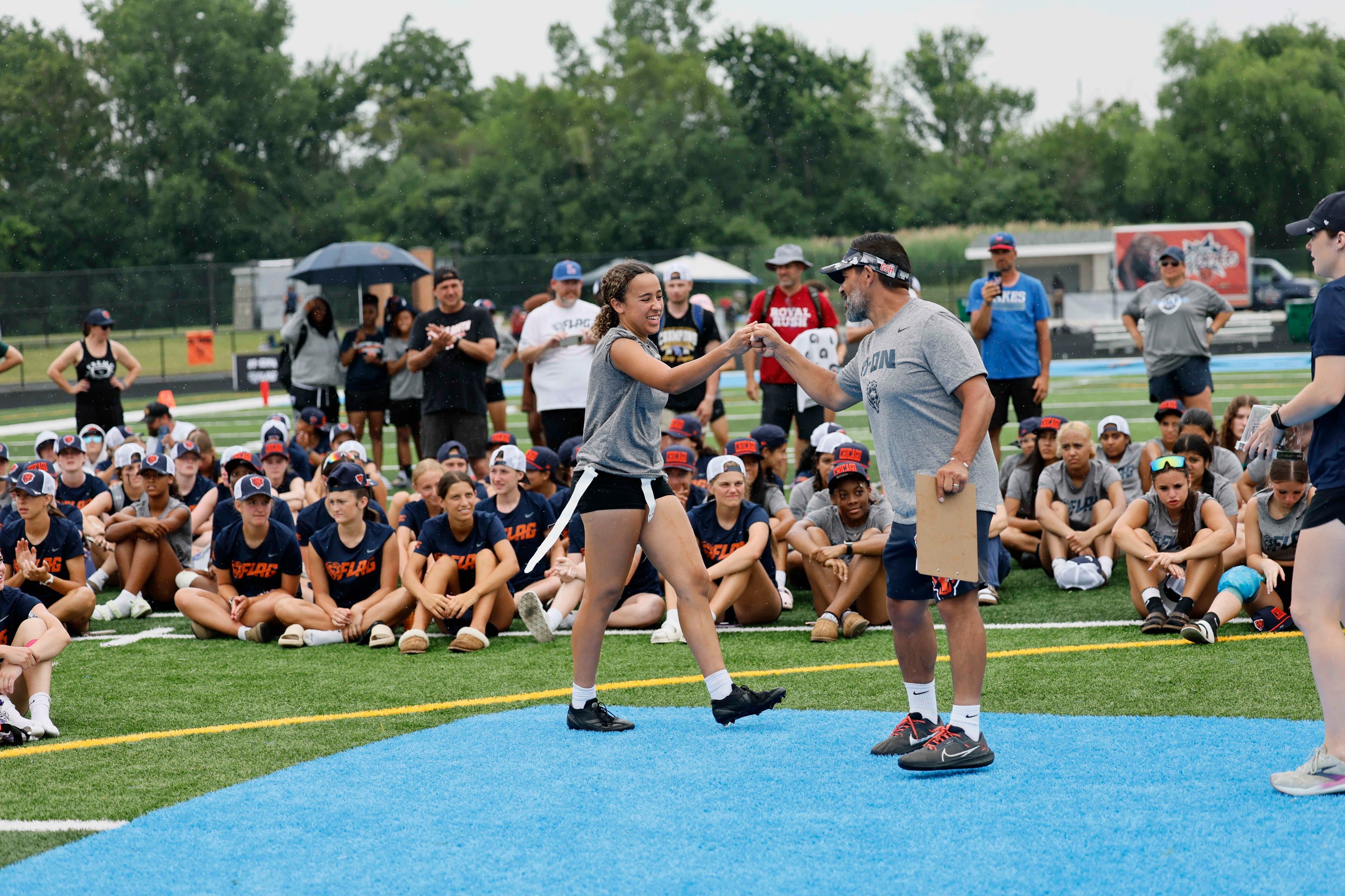 Gustavo Silva (right), the Director of Football Development for the Chicago Bears, works with athletes at an 11 on 11 Girls Flag Football Tournament hosted by the Bears and Nike at Willowbrook High School, on Tuesday, July 8, 2025, in Villa Park, Illinois.