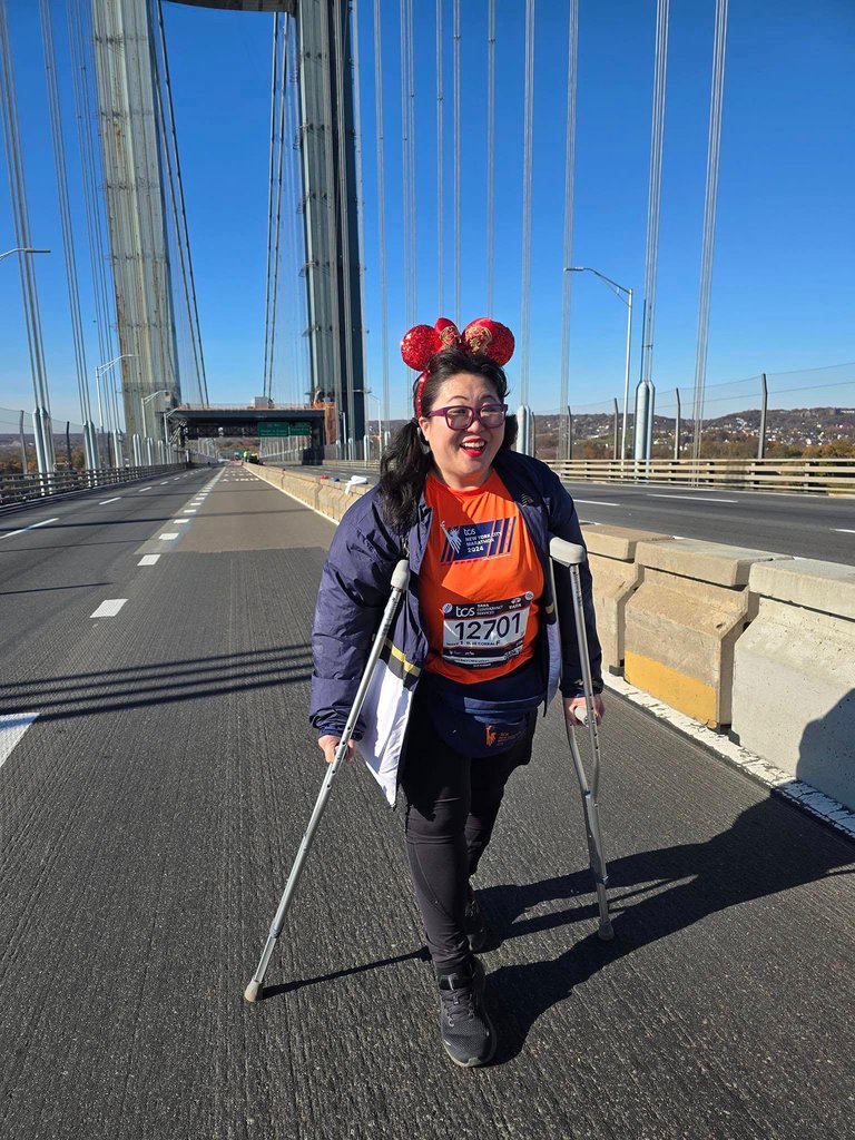 Teresa Hui stands on the Verrazzano Narrows Bridge with crutches at the start of the New York City Marathon.