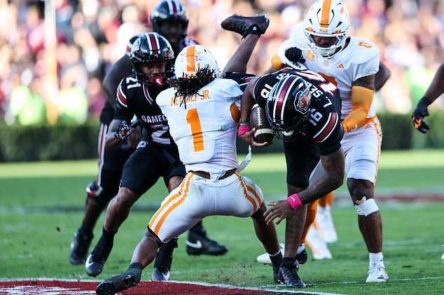 South Carolina quarterback LaNorris Sellers (16) is tackled by Tennessee defensive back TJ Metcalf (1) during the first half of an NCAA college football game Saturday, Oct. 24, 2026, in Columbia, S.C. (AP Photo/Artie Walker Jr.)