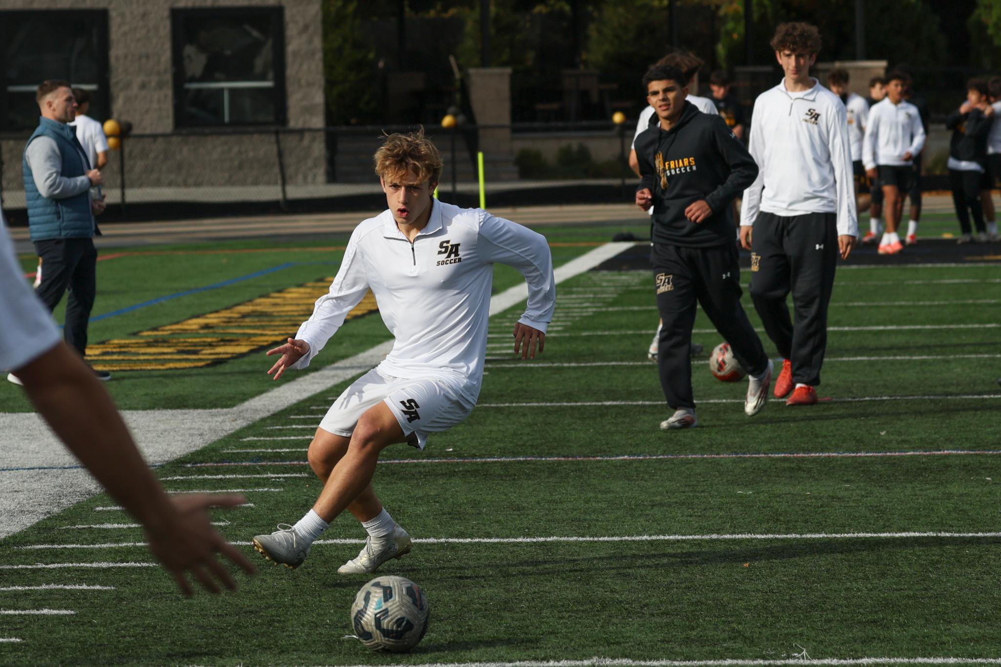 St. Anthony's boys soccer players run drills during practice, with Nick Gentile in the center.