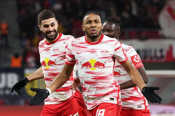 Christopher Nkunku of RB Leipzig celebrates after scoring their sides first goal with team mates Josko Gvardiol and Amadou Haidara during the Bundesliga match between RB Leipzig and 1. FC Köln at Red Bull Arena on February 11, 2022