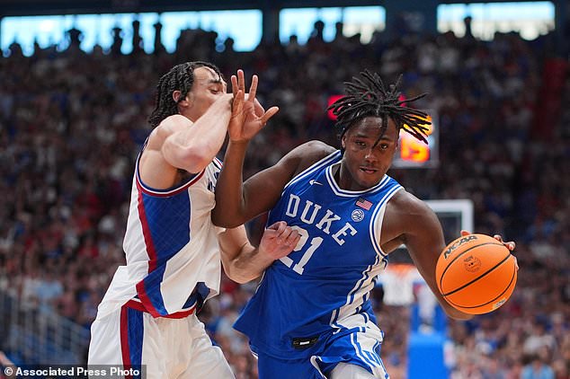 Duke's Patrick Ngongba II (21) shoots drives under pressure from Kansas' Keanu Dawes during the second half of an exhibition NCAA college basketball game Sunday, Oct. 25, 2026, in Lawrence, Kan. (AP Photo/Charlie Riedel)
