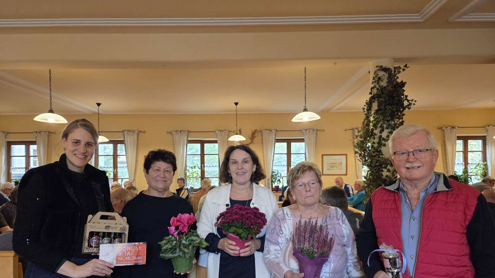 Sophie Sontag-Lohmayer, Agathe Langstein, Claudia Hausberger, Marianne Seisenberger und Georg Wimmer stehen mit Präsenten und Blumen beim Benefiz-Schafkopfen für Donum Vitae Mühldorf-Altötting im Gasthaus des Wildparks Oberreith.