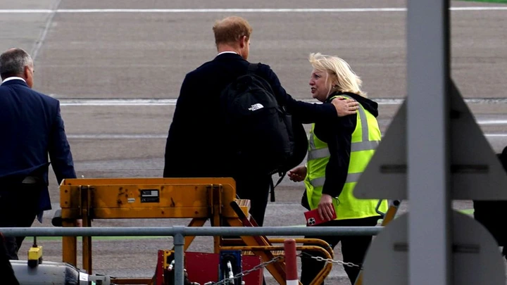 Harry was seen putting his arm around an airport worker at Aberdeen airport as he travelled back to London early this morning.