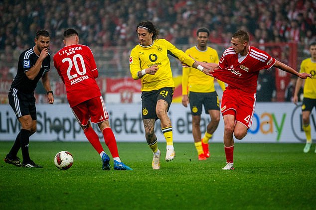 Union's Michel Aebischer, left, Borussia's Fábio Silva, centre, and Union's Zeno Van Den Bosch, right, fight for the ball during the Bundesliga soccer match between Union Berlin and Borussia Dortmund, in Berlin, Saturday, Oct. 17, 2026. (Julius Frick/dpa via AP)