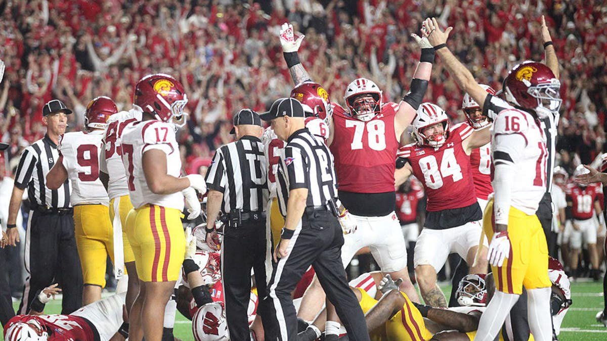 Colin Cubberly signals a touchdown after a pileup at the line during a football game.