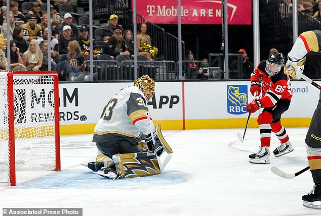 New Jersey Devils center Jack Hughes (86) scores past Vegas Golden Knights goaltender Adin Hill (33) during the second period of an NHL hockey game Friday, Oct. 30, 2026, in Las Vegas. (Steve Marcus/Las Vegas Sun via AP)