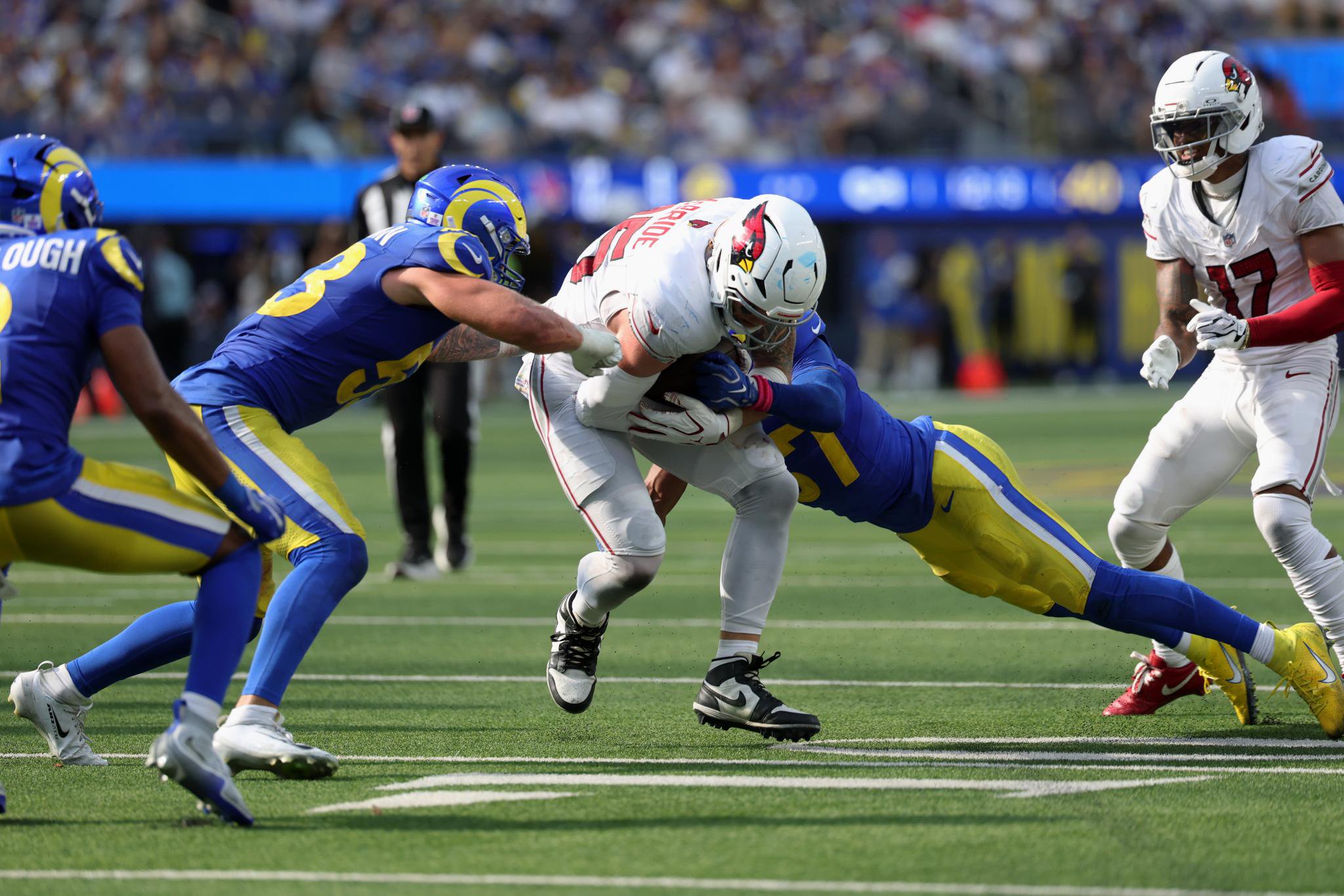 Arizona Cardinals tight end Trey McBride is tackled by Los Angeles Rams defenders.