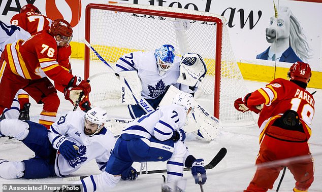 Toronto Maple Leafs goalie Sergei Bobrovsky, center top, blocks a shot by Calgary Flames' Zayne Parekh, right, during the second period of an NHL hockey game in Calgary, Alberta, Monday, Oct. 26, 2026. (Jeff McIntosh/The Canadian Press via AP)