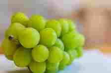 A close-up of a bunch of green grapes with water droplets on them