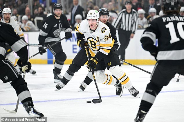Boston Bruins left wing Tanner Jeannot (84) takes the puck up the ice between Los Angeles Kings defenders during the first period of an NHL hockey game Saturday, Oct. 17, 2026, in Los Angeles. (AP Photo/Wally Skalij)