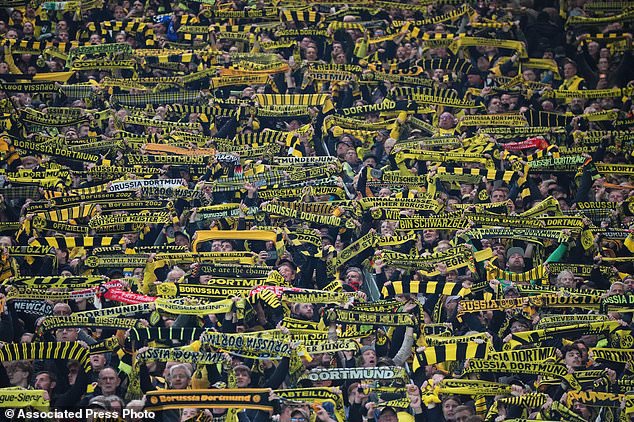Borussia Dortmund's fans hold up their team scarfs prior to the start of the German Bundesliga soccer match between Borussia Dortmund and Werder Bremen in Dortmund, Germany, Friday, Oct. 9, 2026. (AP Photo/Martin Meissner)