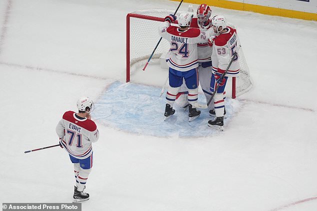 Montreal Canadiens goaltender Jacob Fowler (32) is congratulated by teammates Phillip Danault (24), Noah Dobson (53) and Jake Evans (71) after earning a shutout victory over the St. Louis Blues an NHL hockey game Tuesday, Oct. 27, 2026, in St. Louis. (AP Photo/Jeff Roberson)