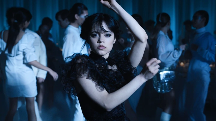 A young woman in a fancy black dress in mid-dance.
