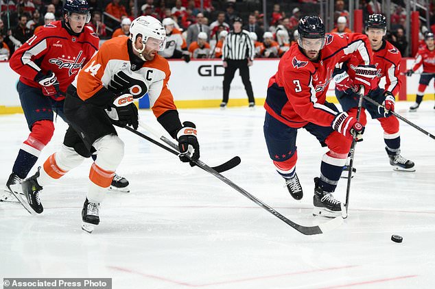 Washington Capitals defenseman Matt Roy (3) and Philadelphia Flyers center Sean Couturier (14) chase the puck during the first period of an NHL hockey game, Wednesday, Oct. 28, 2026, in Washington. (AP Photo/Nick Wass)