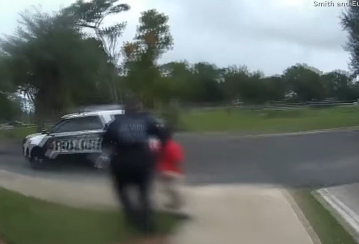 Picture of police officer Dennis Turner seen whisking Kaia to a police car. | Source: Youtube/CBS News