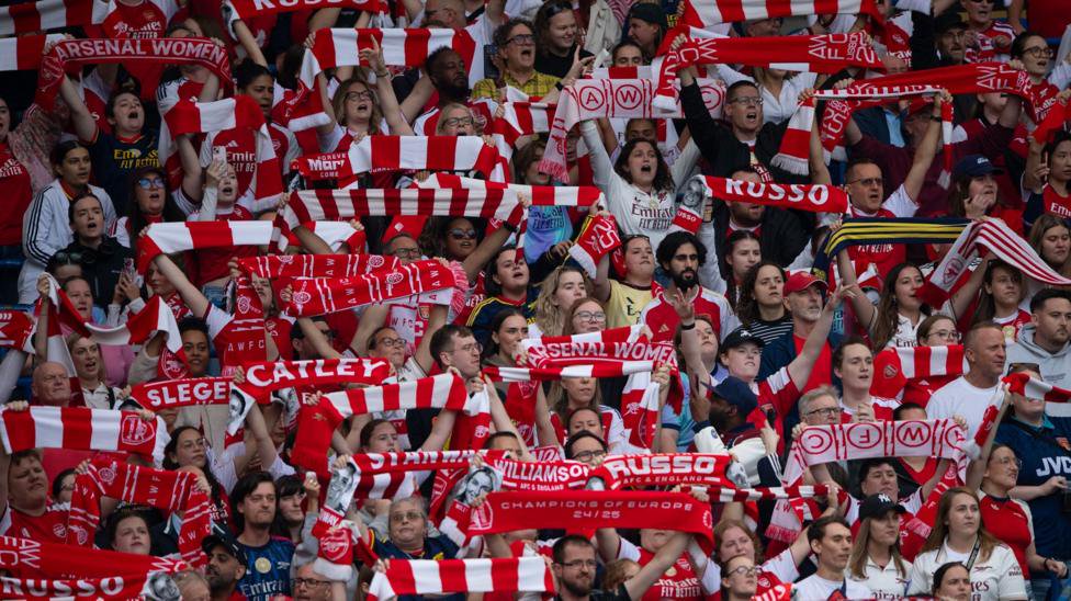 Arsenal fans in stands with scarves 