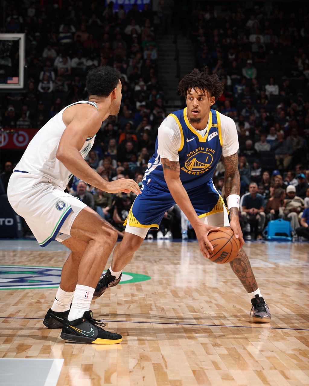 Yaxel Lendeborg of the Golden State Warriors dribbles against a Minnesota Timberwolves defender.
