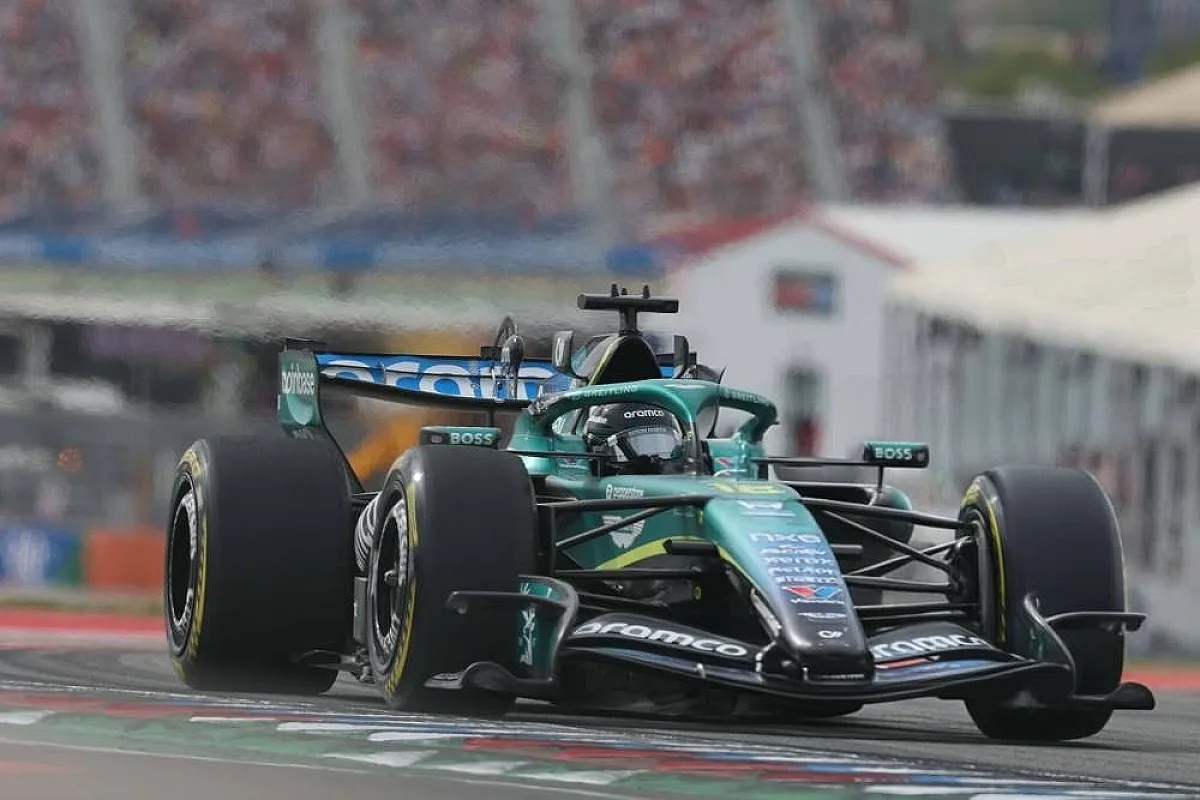 Aston Martin Formula 1 car in green livery with Honda branding, driven on track past grandstands at a race weekend