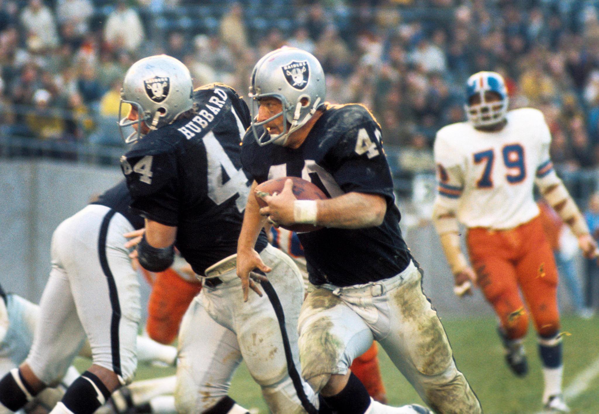 Oakland Raiders running back Pete Banaszak carries the ball, following teammate Marv Hubbard against the Denver Broncos.