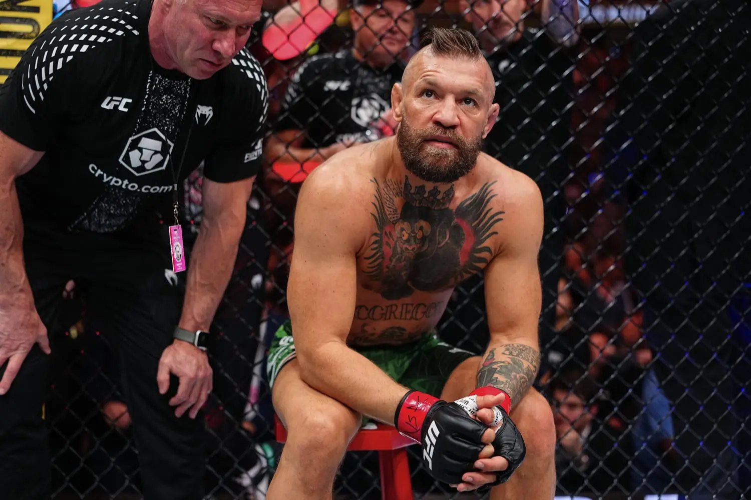 Conor McGregor sentado após grave lesão no UFC 329