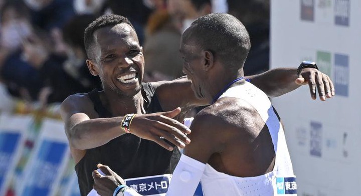 Kenyan Amos Kipruto (L) and his compatriot Eliud Kipchoge (R) react after their finishing the men s category in the Tokyo Marathon in Tokyo on March 6, 2022.