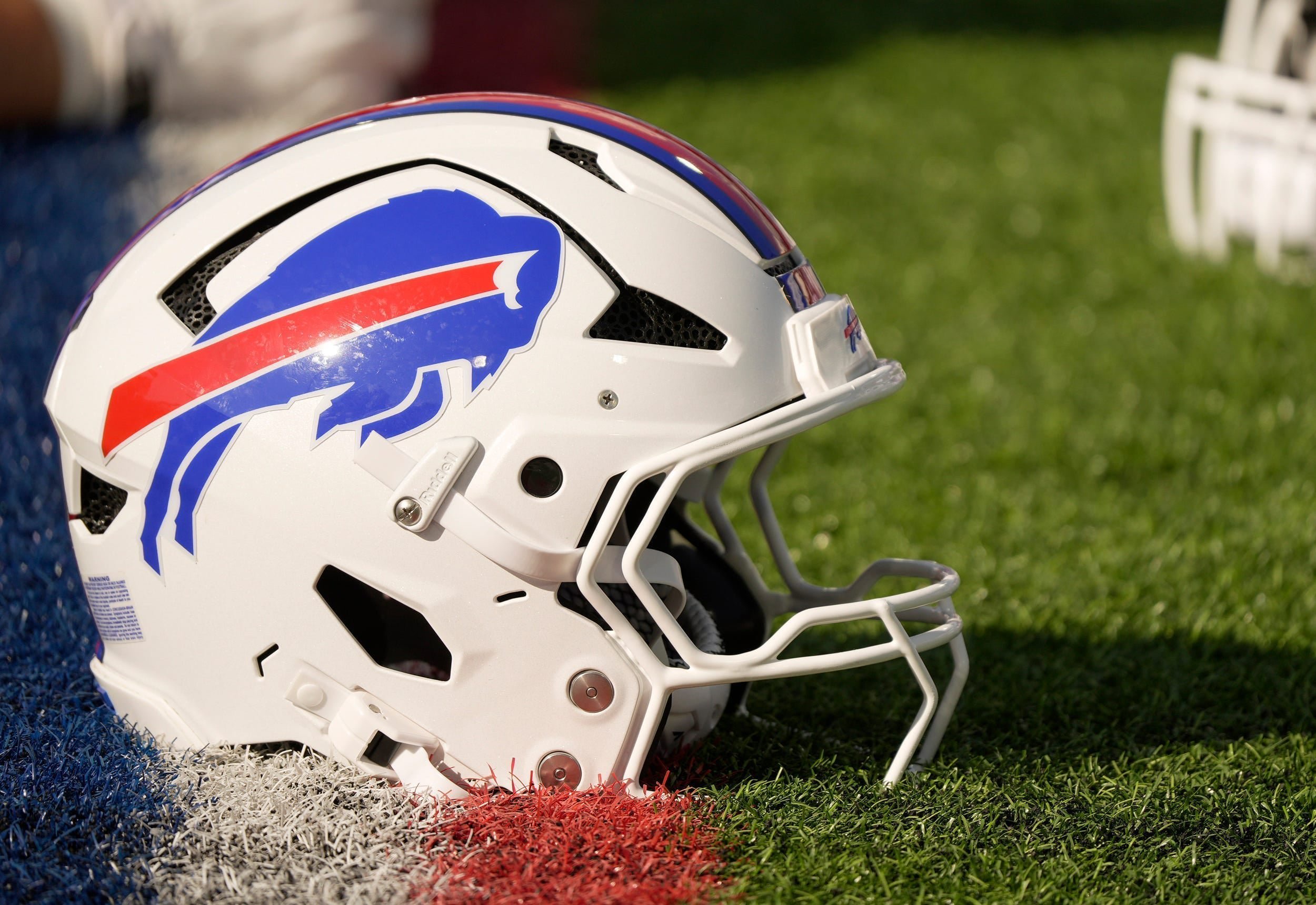 A Buffalo Bills helmet sits on a yard marker during stretching before the Return of the Blue & Red practice at Highmark