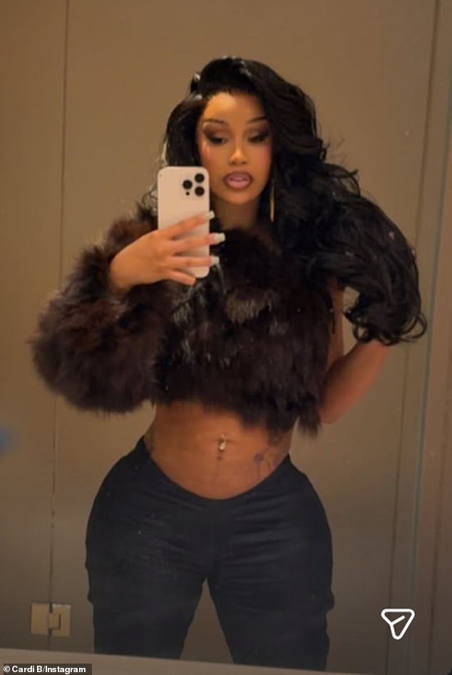 Cardi B flaunted her flat stomach while wearing a faux fur crop-top in a selfie she shared Tuesday - one month after welcoming her fourth child