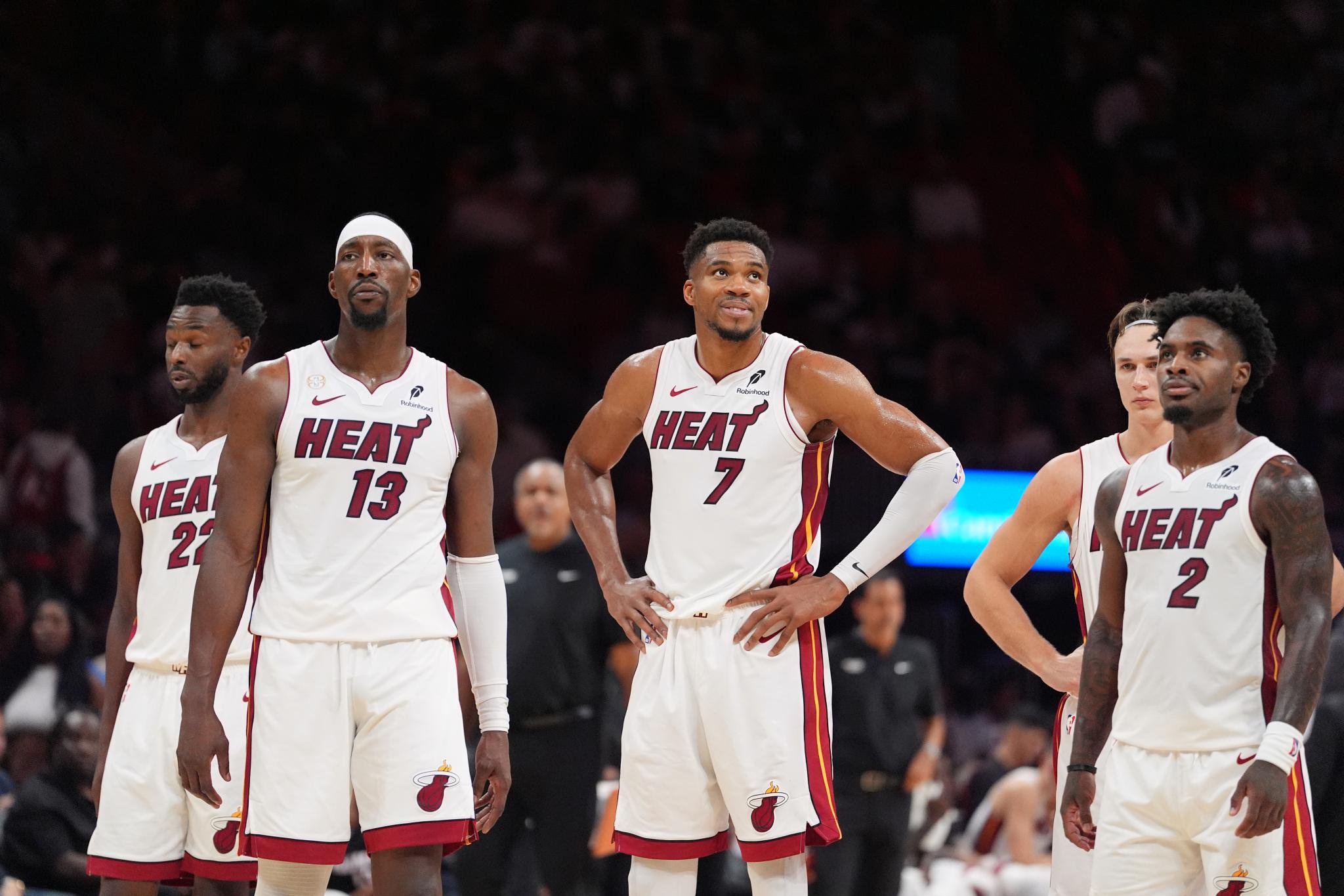 Miami Heat players Bam Adebayo, Giannis Antetokounmpo, and Davion Mitchell react during a game against the Minnesota Timberwolves.