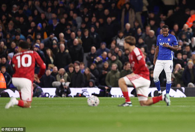 Issa Diop (right) can be seen standing while other players take the knee prior to Ipswich Town's clash with Nottingham Forest on Friday night