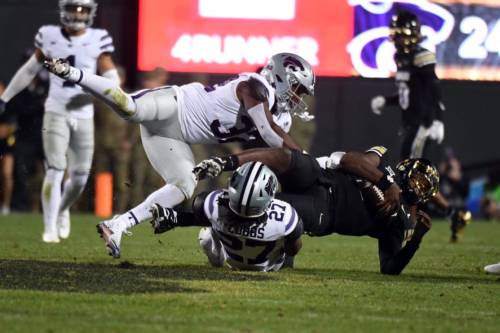 Oct 12, 2024; Boulder, Colorado, USA; Colorado Buffaloes quarterback Shedeur Sanders (2) is tackled by Kansas State Wildcats safety Daniel Cobbs (27) and linebacker Desmond Purnell (32) after a run during the second half at Folsom Field. Mandatory Credit: Christopher Hanewinckel-Imagn Images