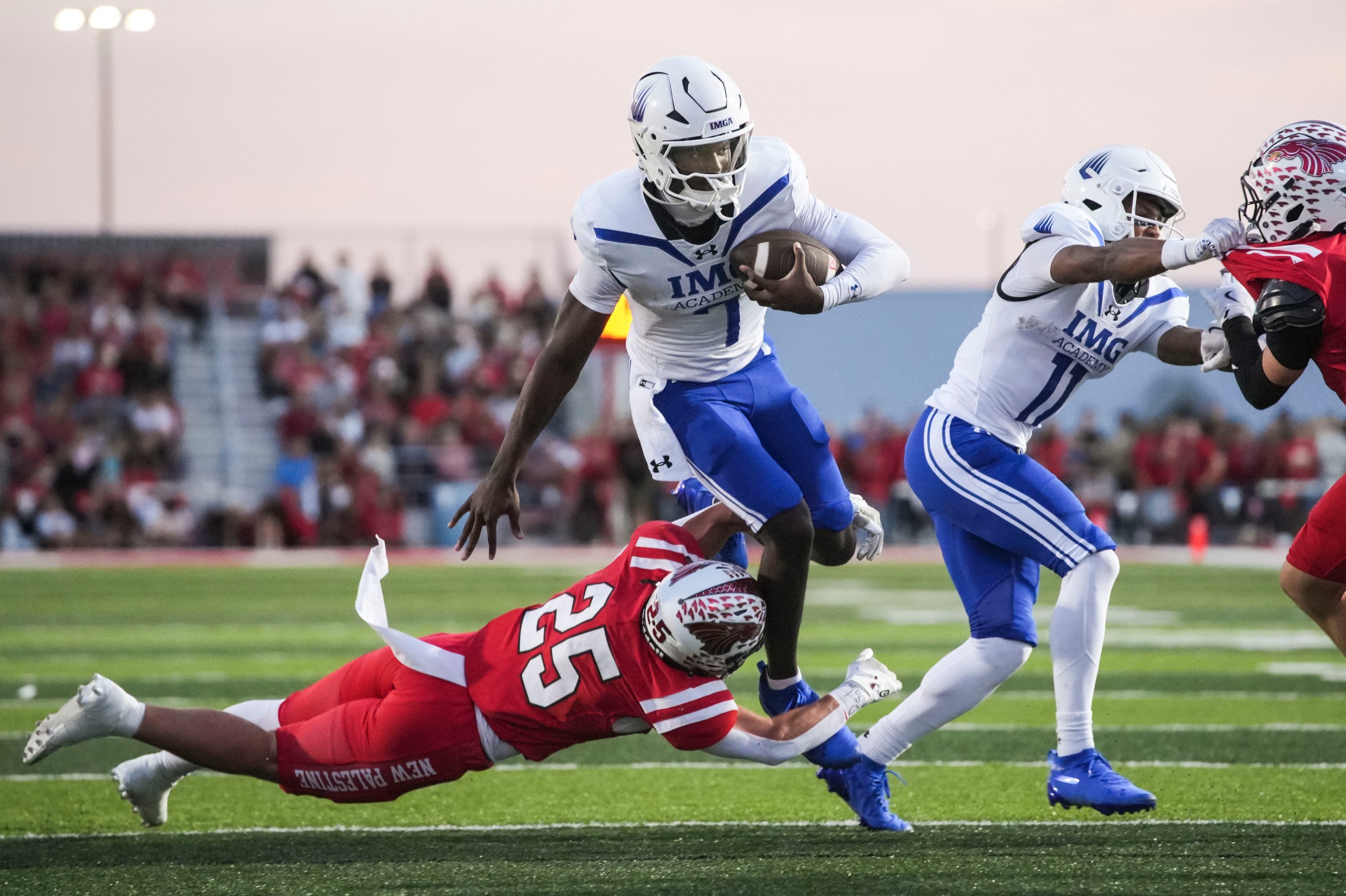 New Palestine Dragons Waynee Estes (25) attempts to tackle IMG Academy Ascenders Jayden Wade 