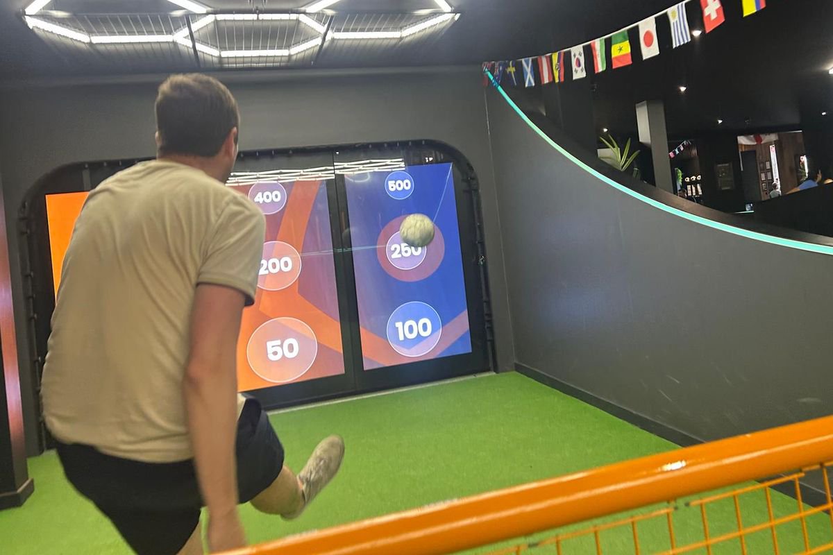 The Daily Star's Neil Docking manages to get a photographer to capture the one time he hit the target in Footy Nation's Score Ball game