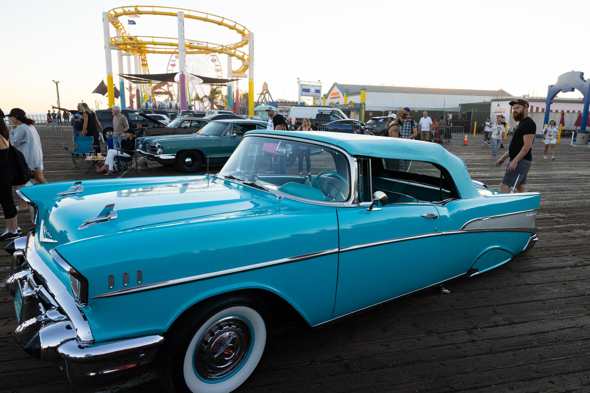 A bright turquoise classic car parked on the Santa Monica Pier during Locals Night, celebrating the Dogtown Z-Boys skate team era.