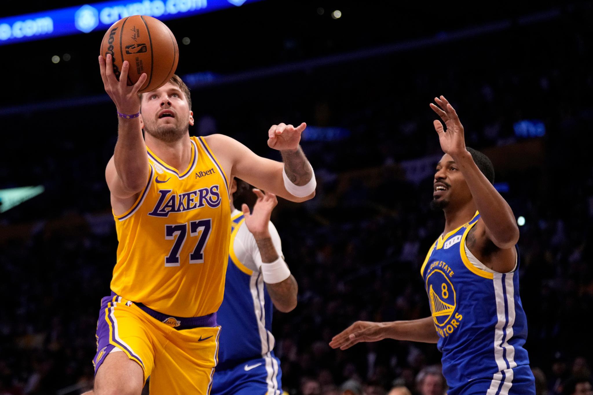 Los Angeles Lakers forward/guard Luka Doncic shoots as Golden State Warriors guard De'anthony Melton defends.