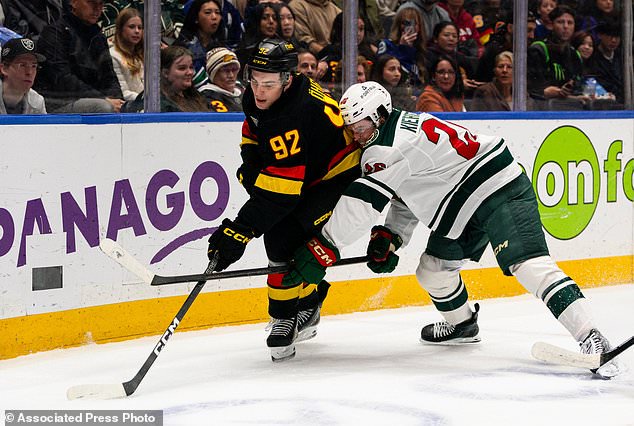 Minnesota Wild's Matt Kiersted, right, checks Vancouver Canucks' Liam Ohgren (92) during the first period of an NHL hockey game, in Vancouver, British Columbia, Sunday, Oct. 25, 2026. (Jacob Mallari/The Canadian Press via AP)