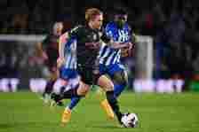 Kevin De Bruyne of Manchester City runs with the ball whilst under pressure from Carlos Baleba of Brighton & Hove Albion during the Premier Lea...