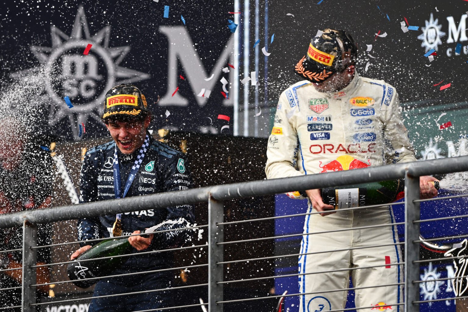 Mercedes driver Andrea Kimi Antonelli celebrates winning the 2026 F1 United States Grand Prix on the COTA podium with Red Bull's Max Verstappen