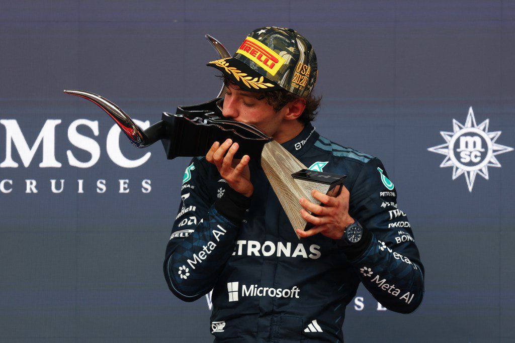 Andrea Kimi Antonelli kisses his trophy on the podium during the F1 Grand Prix of United States.