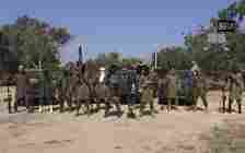 A still taken from a 2014 video released by terror group Boko Haram, showing its masked members brandishing their weapons