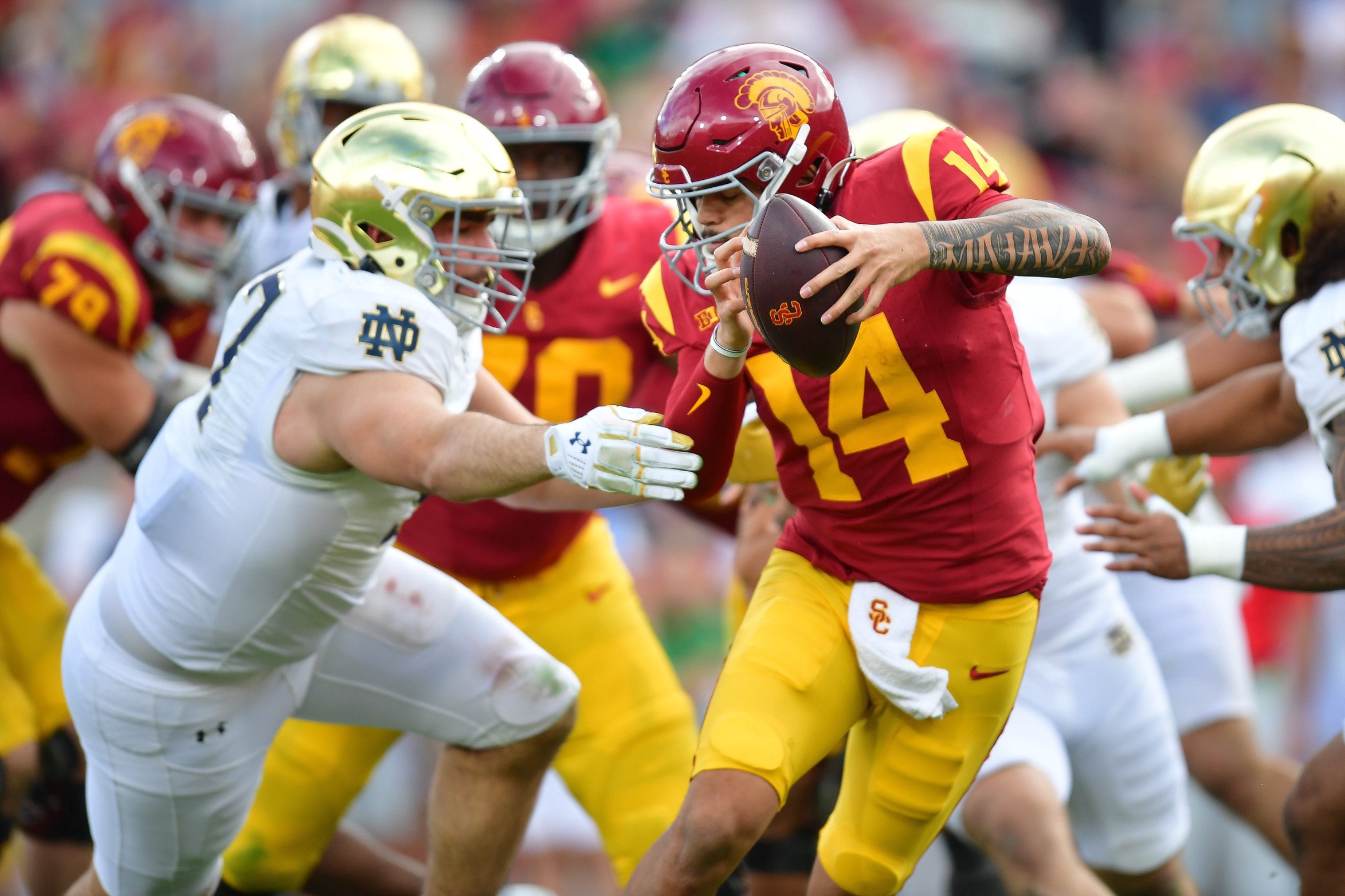 USC Trojans quarterback Jayden Maiava (14) tries to fend off Notre Dame Fighting Irish defensive lineman Gabriel Rubio (97) during an NCAA football game at Los Angeles Memorial Coliseum in Los Angeles, California.