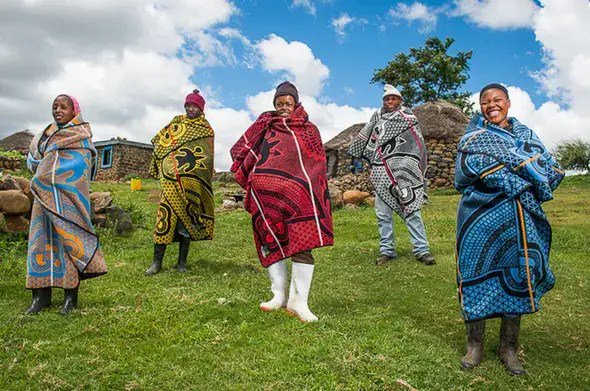 Five people dressed in Sotho African traditional dresses
