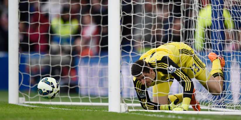 Thibaut Courtois caught up in the net after conceding a goal scored by Charlie Adam
