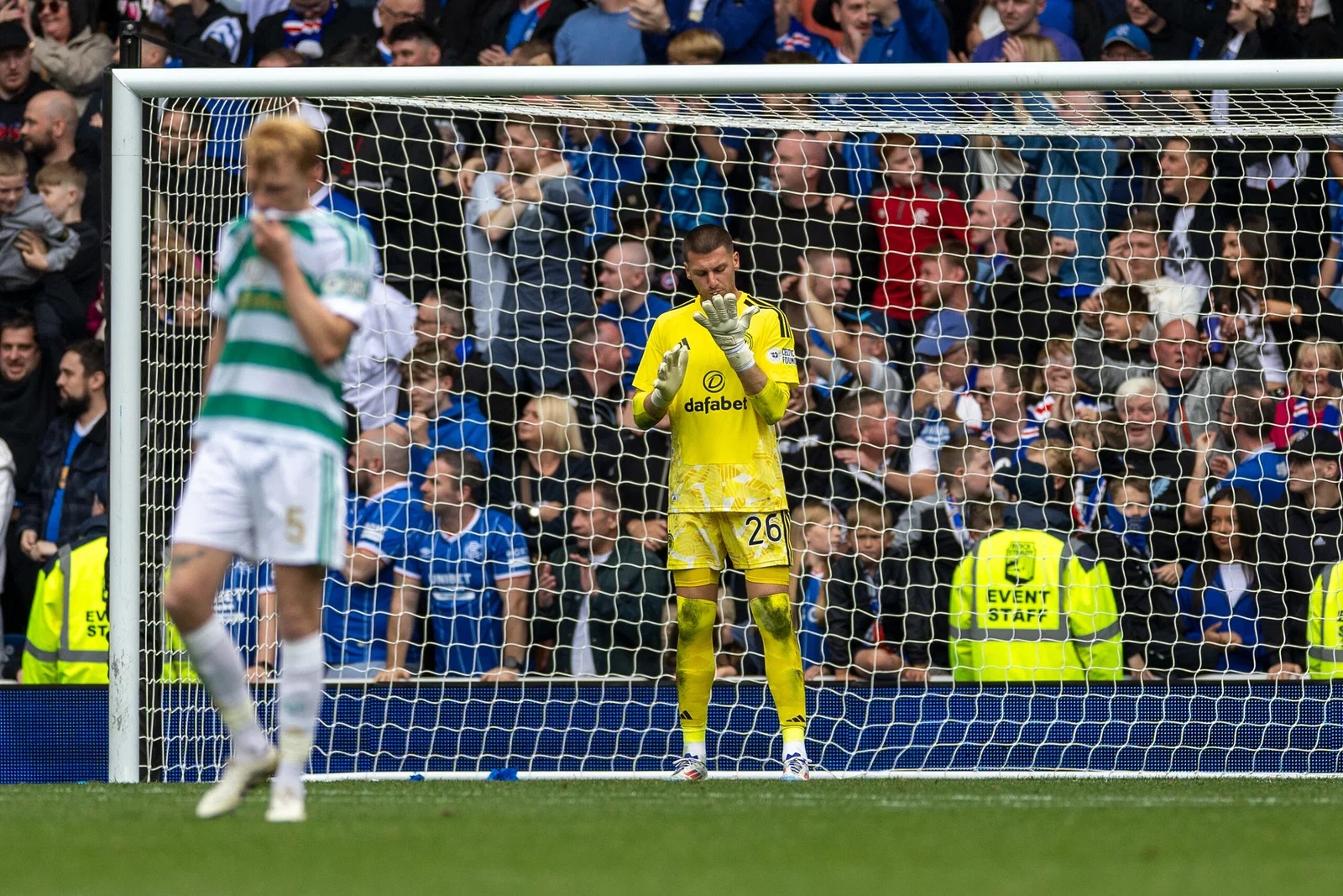 Sam Johnstone of Celtic checks his gloves after Dan Neil of Rangers shoots and scores in the 75th minute to make it 3-0