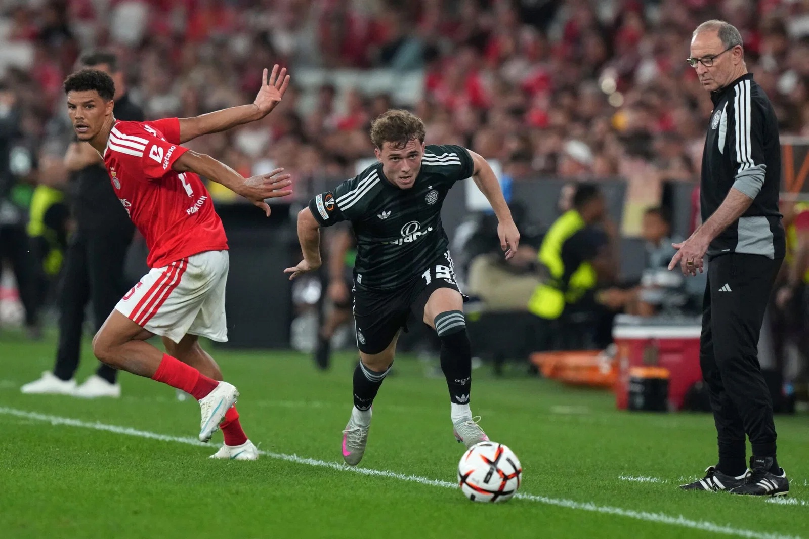 Celtic's Callum Osmand takes the ball past Benfica's Alexander Bah as Martin O'Neill watches in Lisbon