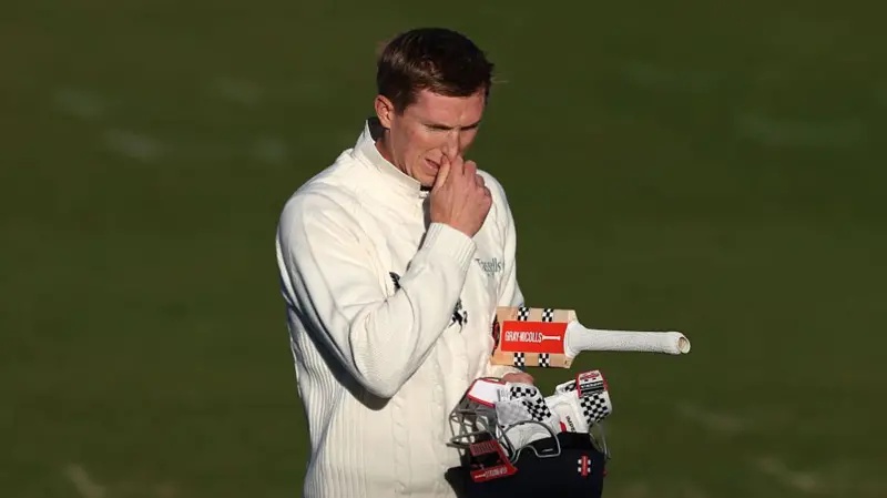 Zak Crawley walks off looking with gloves, bat and helmet in hand