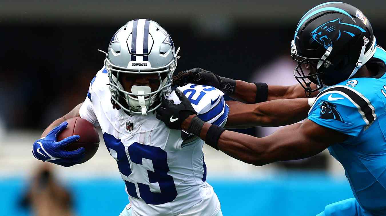 CHARLOTTE, NORTH CAROLINA - OCTOBER 12: Jaydon Blue #23 of the Dallas Cowboys carries the ball while pressured by Mike Jackson #2 of the Carolina Panthers in the game at Bank of America Stadium on October 12, 2025 in Charlotte, North Carolina. (Photo by Grant Halverson/Getty Images)