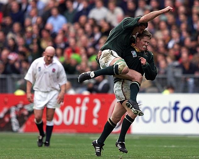 Jannie de Beer (right) celebrates with Joost van der Westhuizen as the fly-half's five drop-goals - a plan concocted by Venter - knocked England out of the 1999 World Cup